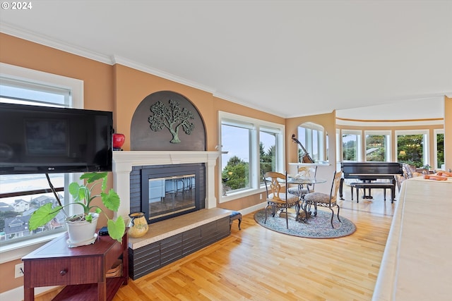 living room featuring crown molding, wood-type flooring, and a brick fireplace