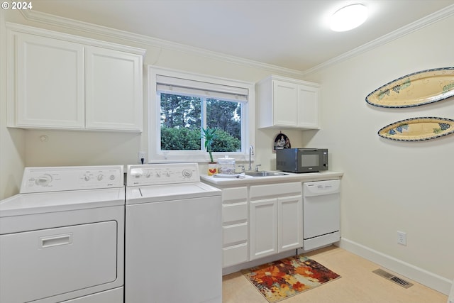 laundry room featuring washing machine and dryer, crown molding, and sink