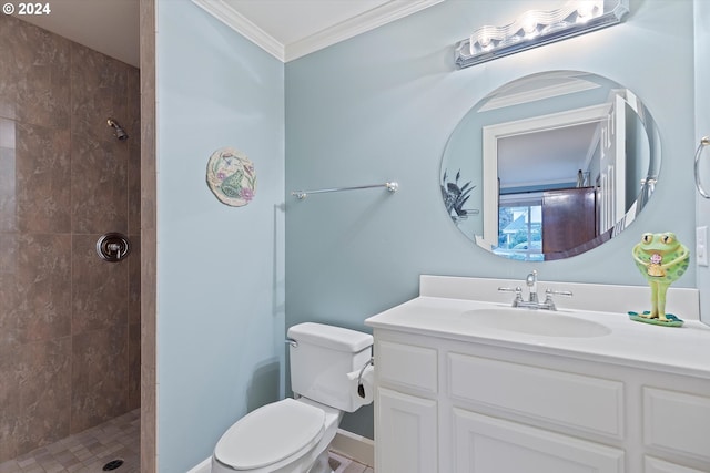 bathroom with a tile shower, vanity, ornamental molding, and toilet