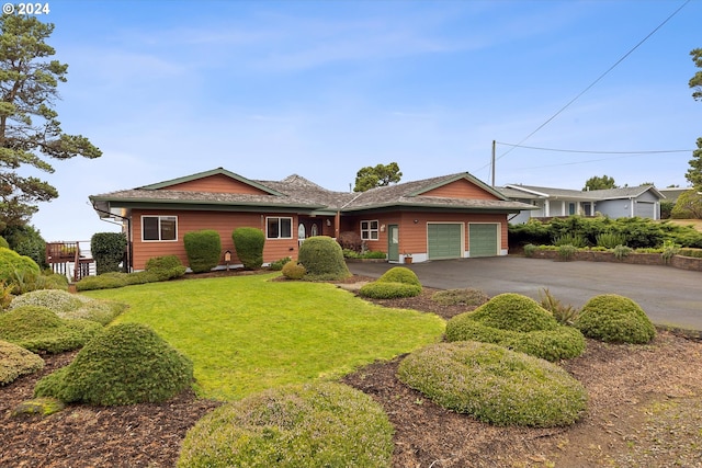 single story home with a front yard and a garage