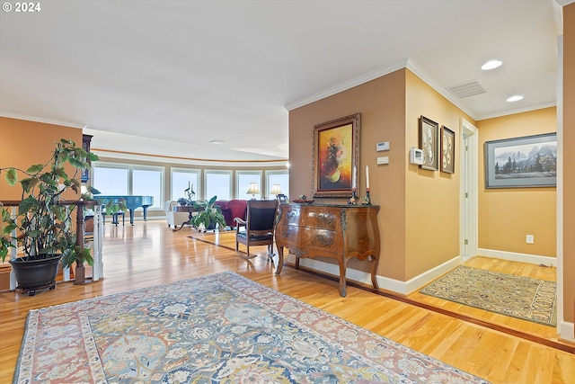 hallway with hardwood / wood-style floors and ornamental molding