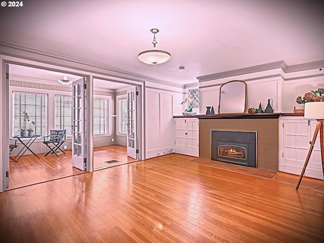 unfurnished living room featuring light hardwood / wood-style flooring and ornamental molding