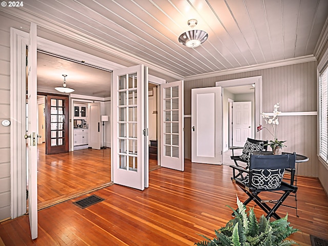 unfurnished room with french doors, crown molding, and hardwood / wood-style floors