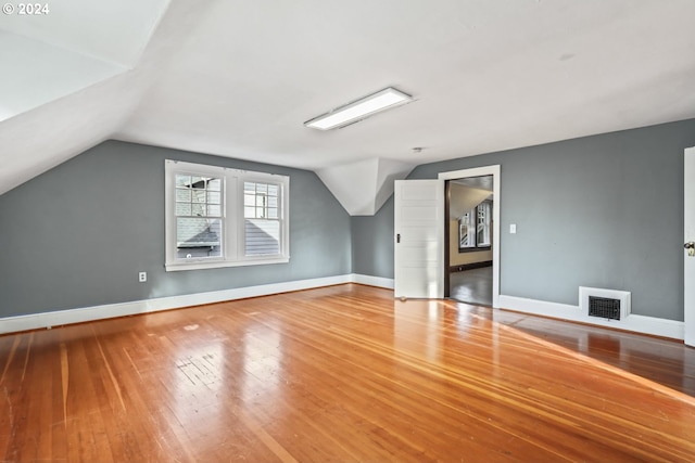 bonus room with hardwood / wood-style flooring and lofted ceiling