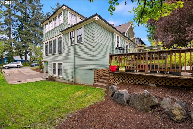 view of property exterior with a wooden deck and a yard