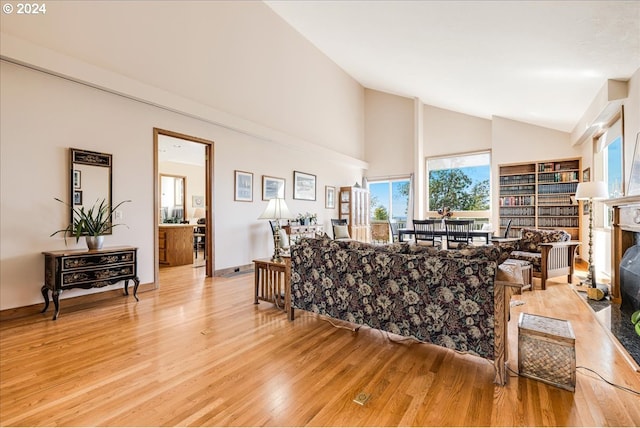 living room featuring high vaulted ceiling and light wood-type flooring