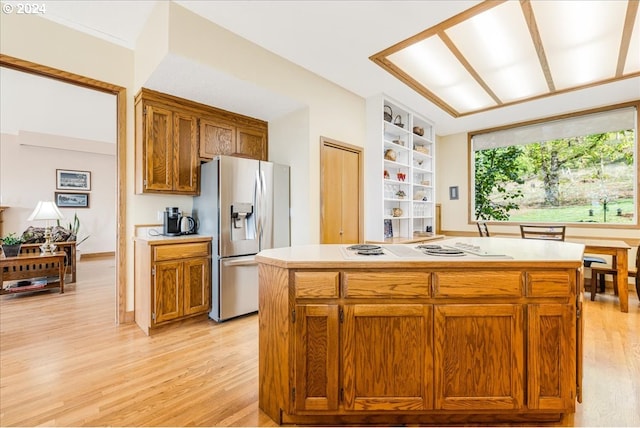 kitchen featuring stainless steel fridge, light wood-type flooring, and a kitchen island