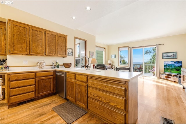 kitchen with sink, dishwasher, kitchen peninsula, and light hardwood / wood-style floors