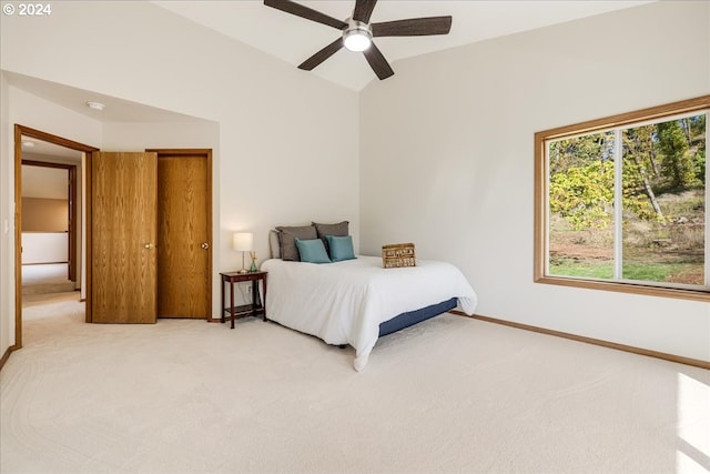 bedroom featuring lofted ceiling, light colored carpet, and ceiling fan