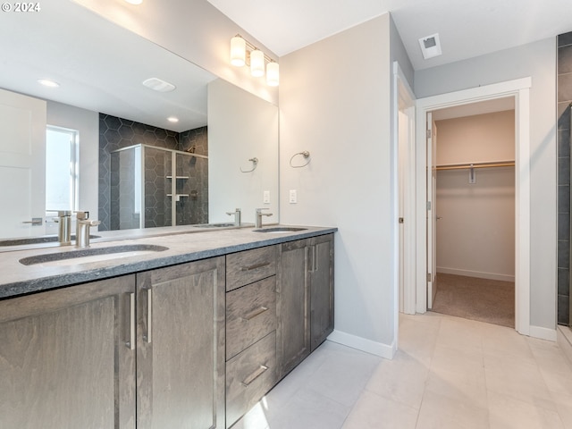 bathroom with tile patterned floors, vanity, and an enclosed shower