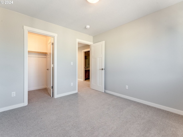 unfurnished bedroom with a walk in closet and a closet