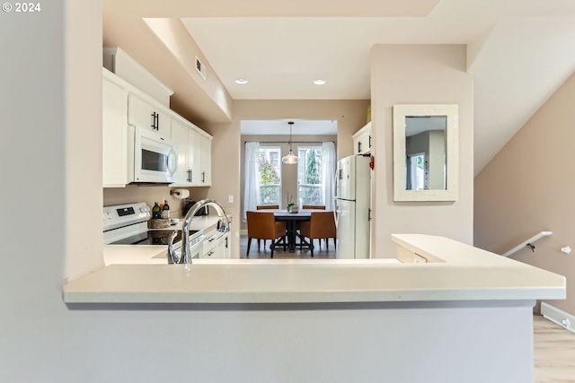 kitchen featuring kitchen peninsula, white appliances, pendant lighting, light hardwood / wood-style flooring, and white cabinetry