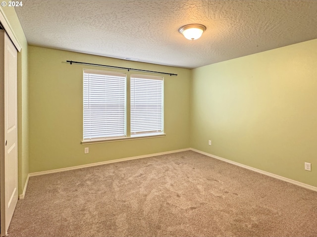 carpeted spare room with a textured ceiling