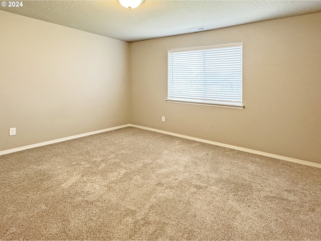 carpeted spare room featuring a textured ceiling