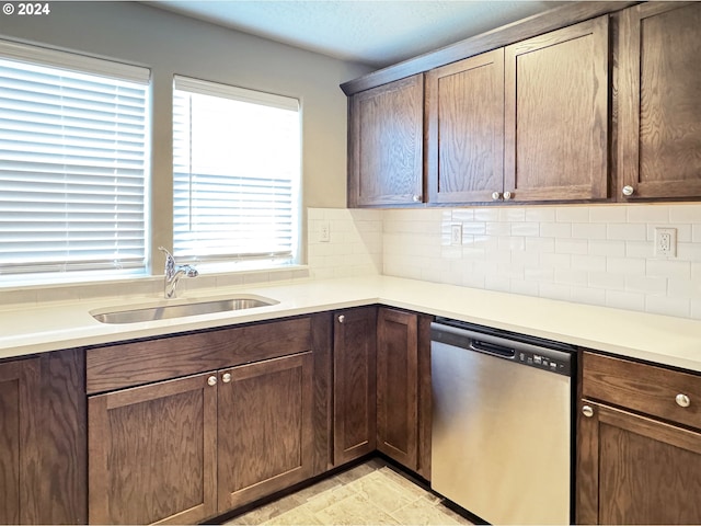 kitchen with dark brown cabinets, tasteful backsplash, stainless steel dishwasher, and sink