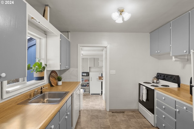 kitchen featuring gray cabinets, white appliances, tasteful backsplash, and sink