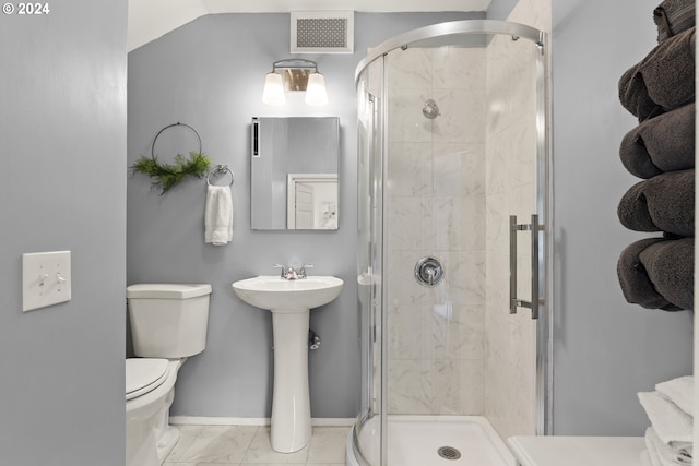 bathroom featuring toilet and a shower with shower door