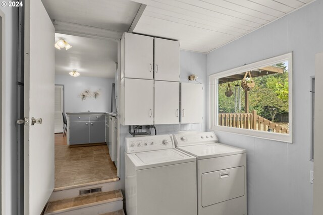 laundry room with independent washer and dryer and cabinets