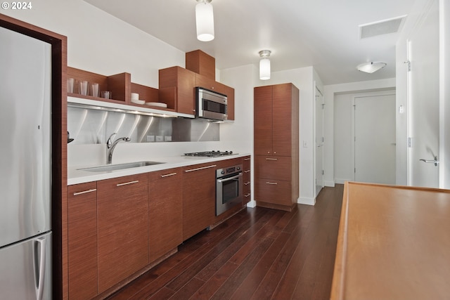 kitchen featuring stainless steel appliances, dark wood-type flooring, and sink