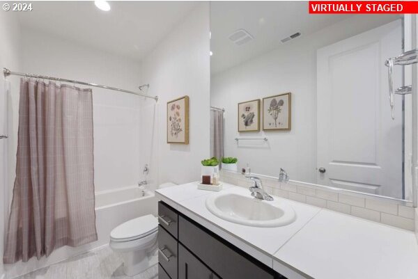 full bathroom featuring shower / bath combination with curtain, vanity, and toilet