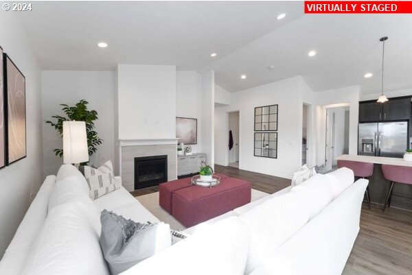 living room featuring wood-type flooring and vaulted ceiling