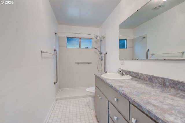 bathroom featuring a shower, vanity, and toilet