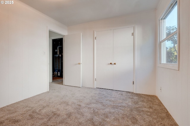 unfurnished bedroom with carpet floors, multiple windows, and crown molding