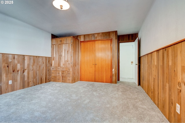 bedroom featuring wood walls and carpet floors