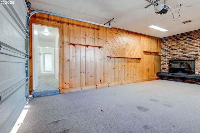 unfurnished living room with a textured ceiling, carpet floors, and wooden walls