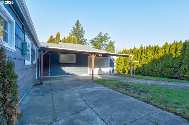 view of property exterior featuring a garage, a carport, and a lawn