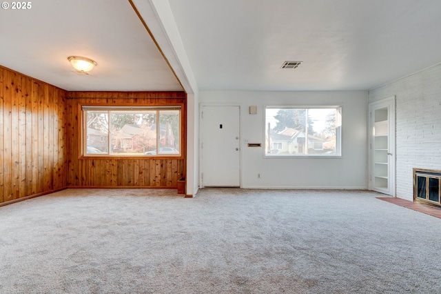 unfurnished living room with a fireplace, light carpet, and a healthy amount of sunlight