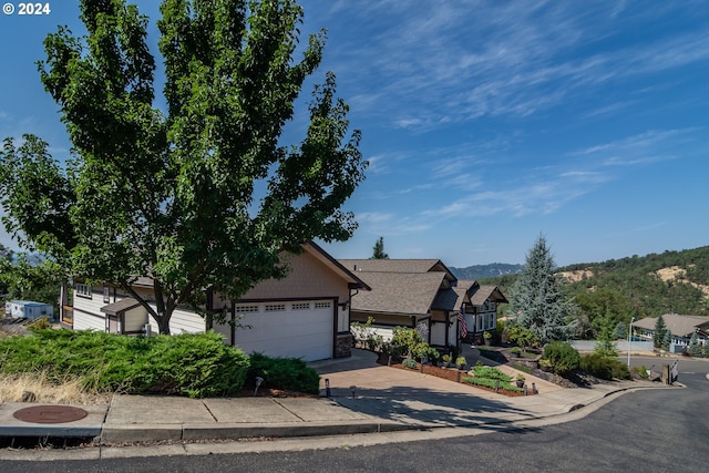 view of front of property with an attached garage, stone siding, and driveway