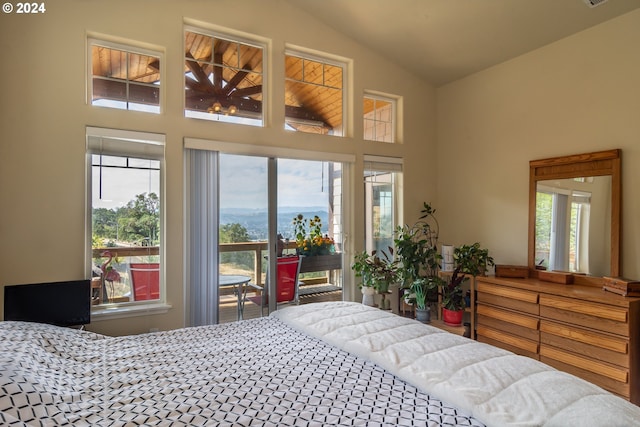 bedroom with multiple windows, lofted ceiling, and access to outside