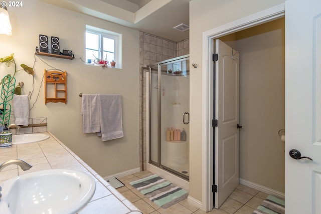 bathroom featuring tile patterned floors, baseboards, a stall shower, and a sink