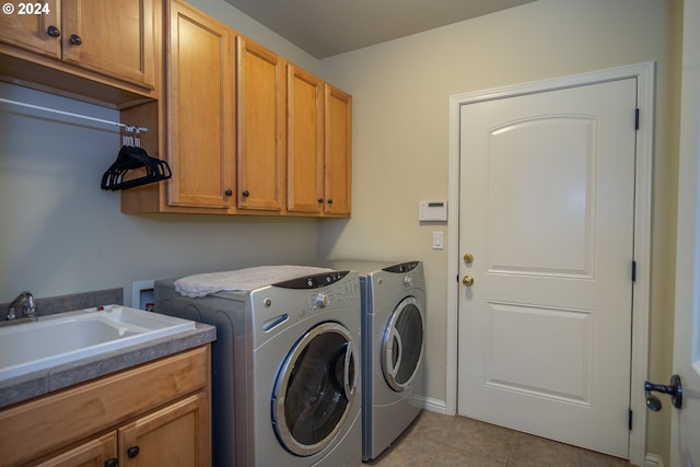 laundry area with a sink, cabinet space, tile patterned flooring, and washer and clothes dryer