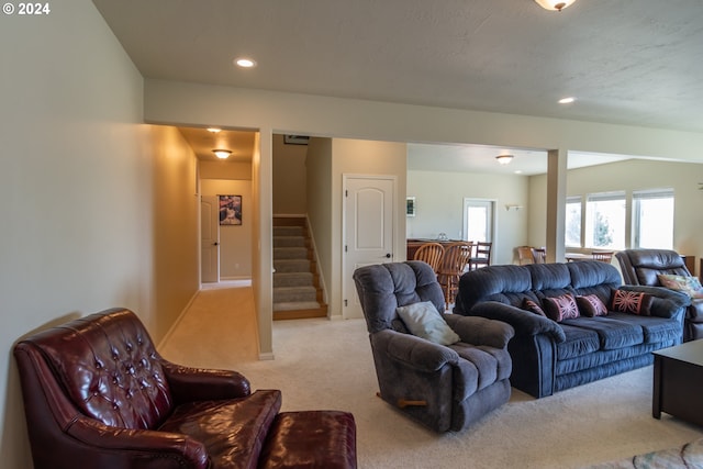 carpeted living area with stairway and recessed lighting