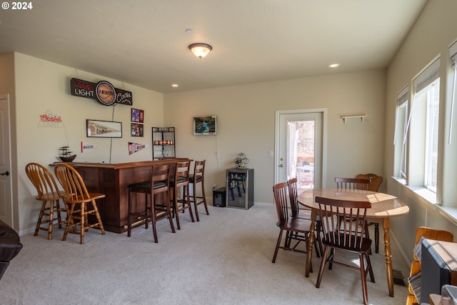 dining room with a bar, recessed lighting, carpet, and baseboards