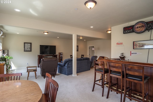 dining room featuring recessed lighting, light colored carpet, and a bar