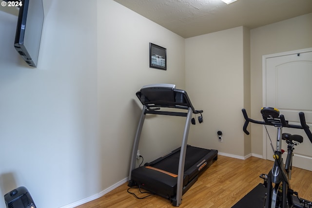 workout area with baseboards and light wood-type flooring