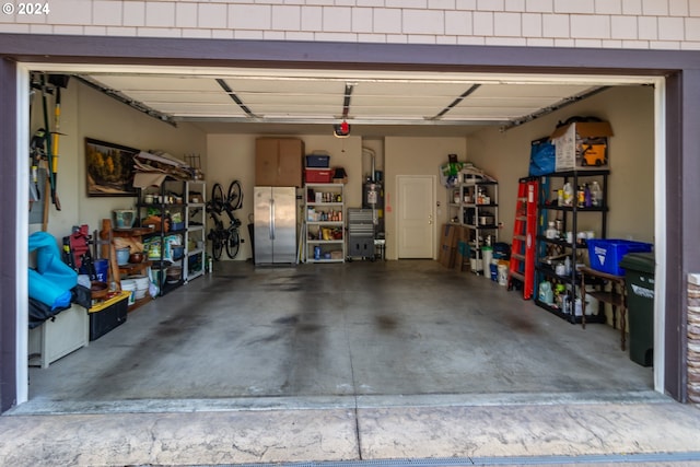 garage with a garage door opener and freestanding refrigerator