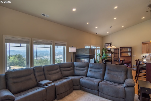 living area with visible vents, light colored carpet, recessed lighting, a mountain view, and high vaulted ceiling