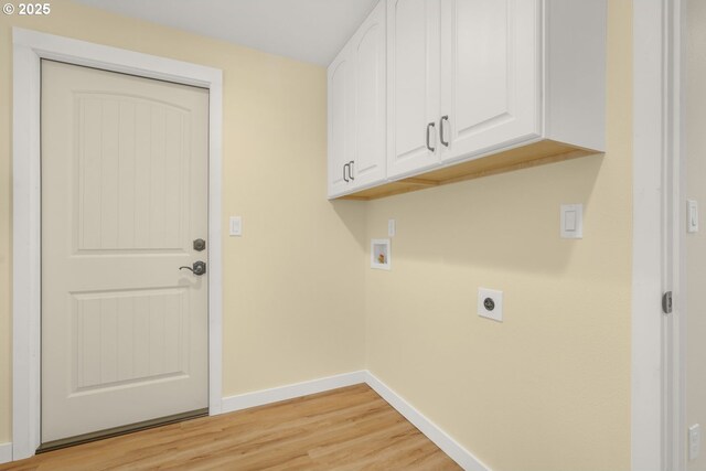 washroom featuring electric dryer hookup, hookup for a washing machine, light hardwood / wood-style flooring, and cabinets