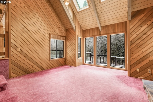 unfurnished living room featuring carpet and wood walls