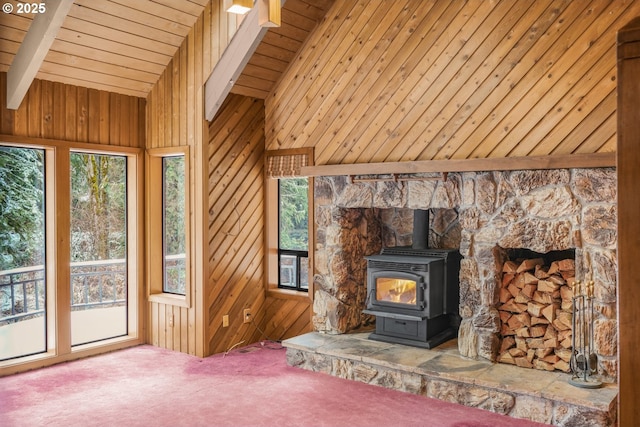 unfurnished living room with wood ceiling, a wood stove, vaulted ceiling with beams, carpet floors, and wood walls