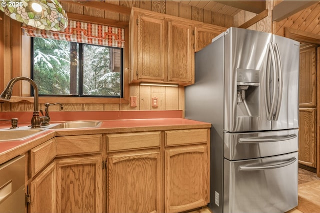 kitchen featuring light countertops, stainless steel refrigerator with ice dispenser, and a sink