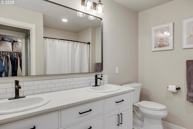 bathroom with vanity, backsplash, and toilet