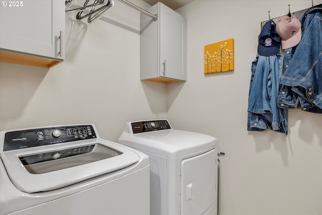 washroom featuring separate washer and dryer and cabinets