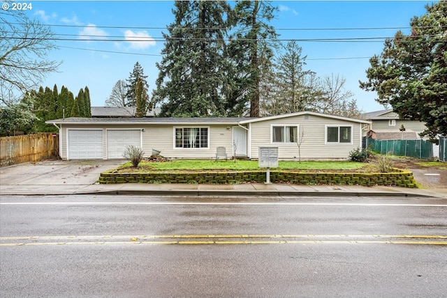 ranch-style home with solar panels, a garage, and a front lawn