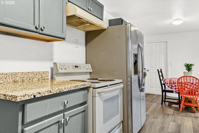 kitchen featuring gray cabinetry, light stone countertops, light hardwood / wood-style floors, and white electric stove