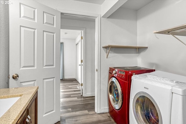 clothes washing area featuring separate washer and dryer and wood-type flooring